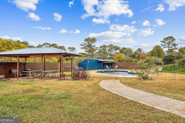 view of yard featuring a fenced in pool and an outdoor structure