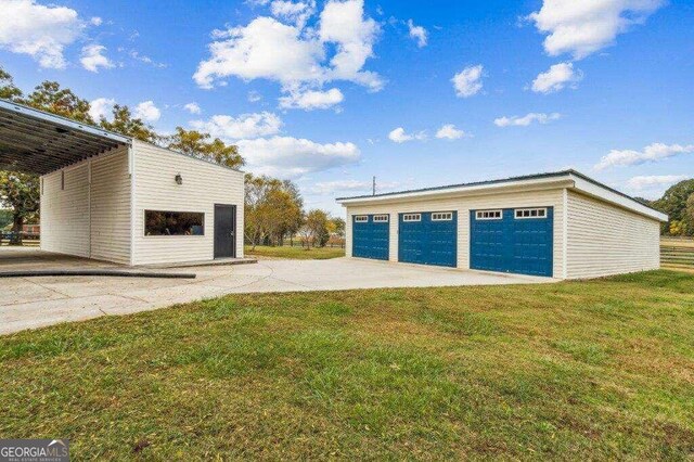 garage with a lawn and a carport