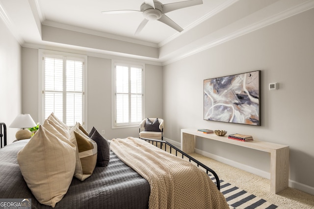 carpeted bedroom featuring ceiling fan, a raised ceiling, and ornamental molding