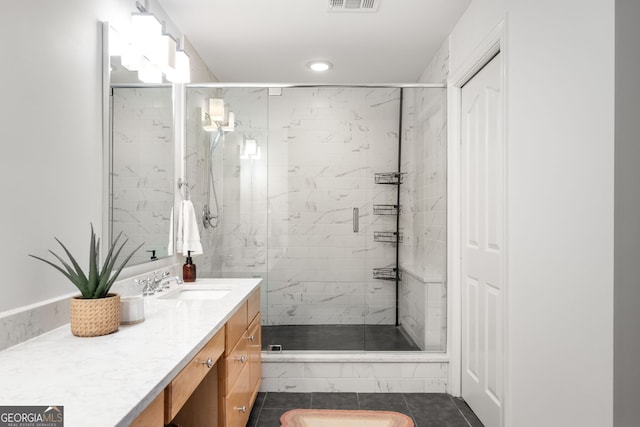 bathroom with vanity, walk in shower, and tile patterned flooring