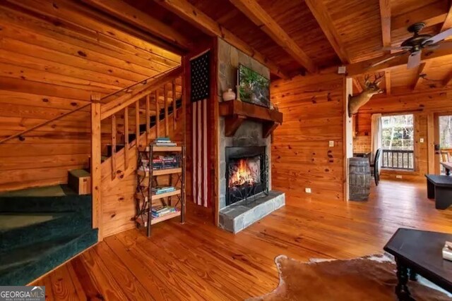 unfurnished living room with wood walls, wooden ceiling, beamed ceiling, and hardwood / wood-style floors