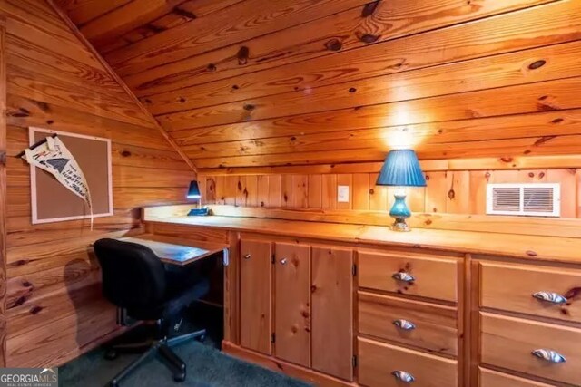 office space featuring lofted ceiling, wooden walls, wooden ceiling, and dark colored carpet