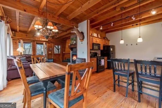 dining space featuring beam ceiling, light hardwood / wood-style flooring, wood ceiling, and an inviting chandelier