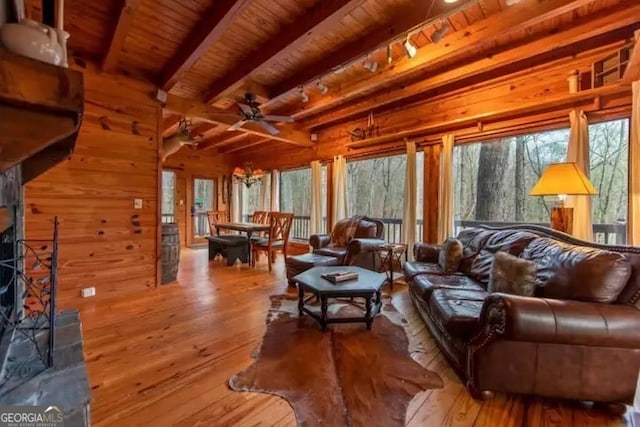 living room with beamed ceiling, wooden walls, wood ceiling, and wood-type flooring