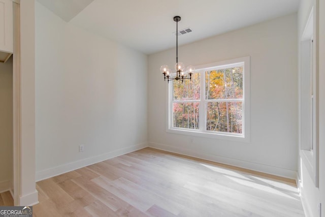 unfurnished dining area with a chandelier, light hardwood / wood-style flooring, and a healthy amount of sunlight