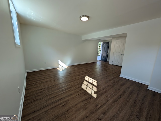 unfurnished room with dark hardwood / wood-style flooring