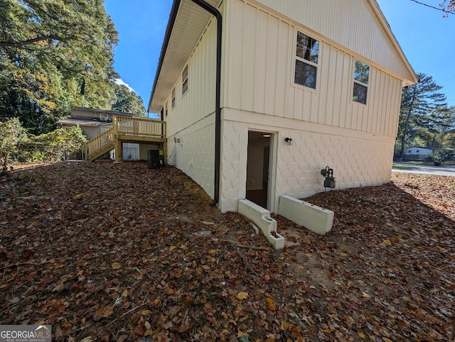 view of side of home with central AC unit and a deck