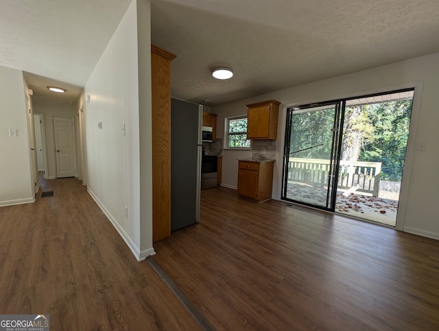 kitchen featuring appliances with stainless steel finishes, backsplash, dark hardwood / wood-style floors, and a textured ceiling