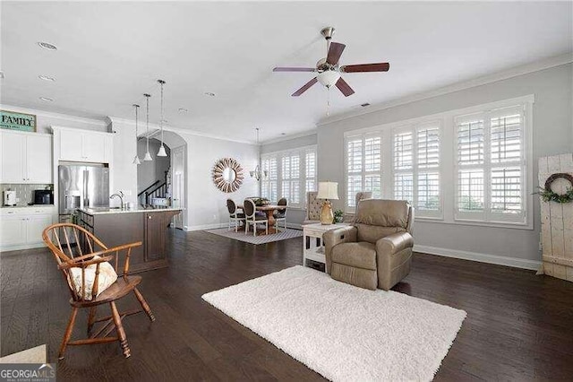 living room with ceiling fan, ornamental molding, and dark hardwood / wood-style floors