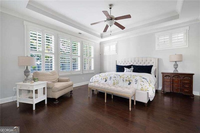 bedroom featuring dark hardwood / wood-style flooring, a tray ceiling, and ceiling fan