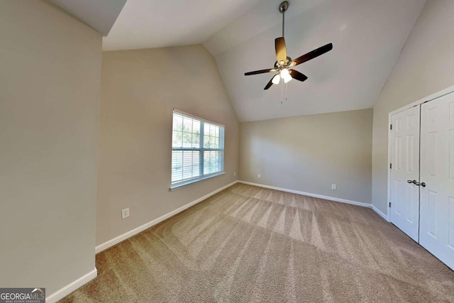 unfurnished bedroom featuring ceiling fan, carpet flooring, and vaulted ceiling