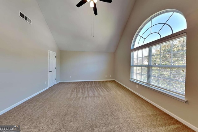 carpeted empty room featuring ceiling fan and high vaulted ceiling