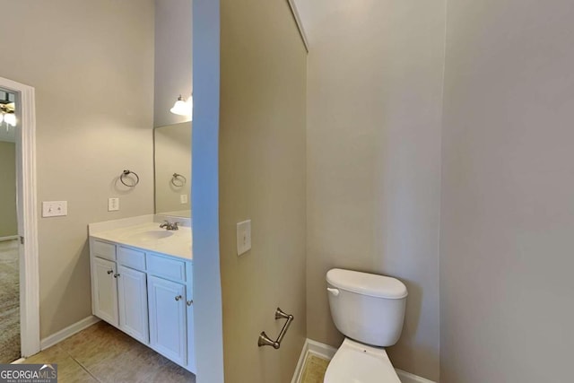 bathroom with toilet, vanity, and tile patterned floors