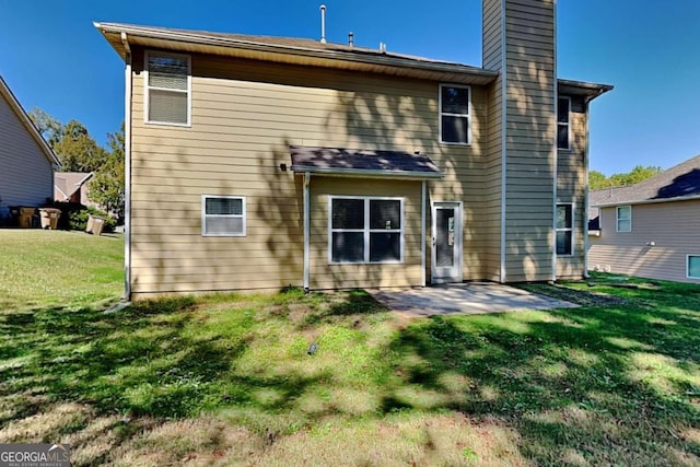 back of house with a yard and a patio