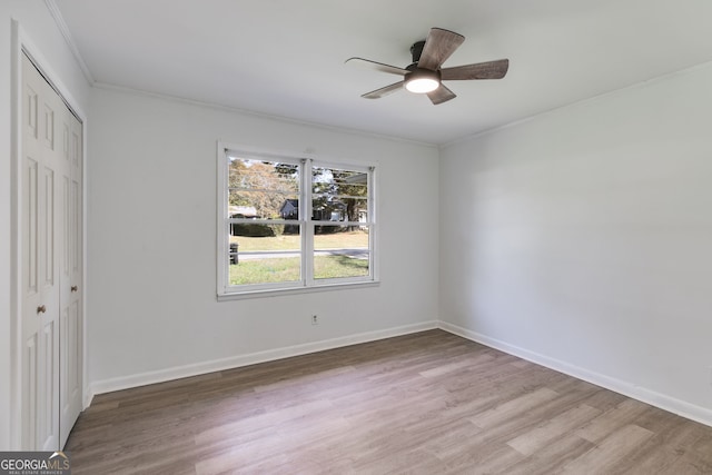 unfurnished bedroom with ornamental molding, hardwood / wood-style floors, a closet, and ceiling fan