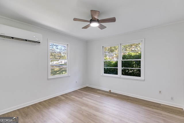 empty room featuring light wood-type flooring, an AC wall unit, plenty of natural light, and ceiling fan