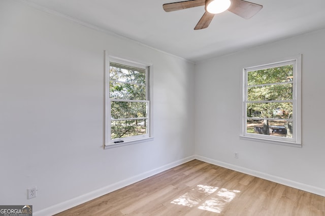 unfurnished room featuring ornamental molding, light wood-type flooring, a healthy amount of sunlight, and ceiling fan