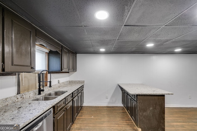 kitchen with stainless steel dishwasher, sink, dark brown cabinets, and dark hardwood / wood-style floors