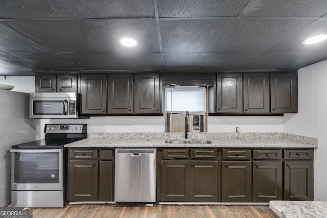 kitchen featuring hardwood / wood-style flooring, stainless steel appliances, and dark brown cabinetry