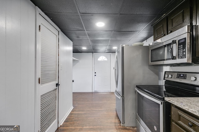 kitchen with dark hardwood / wood-style floors, light stone countertops, dark brown cabinetry, appliances with stainless steel finishes, and a paneled ceiling