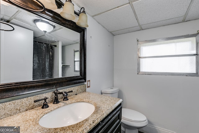 bathroom with toilet, a paneled ceiling, vanity, and a shower with shower curtain