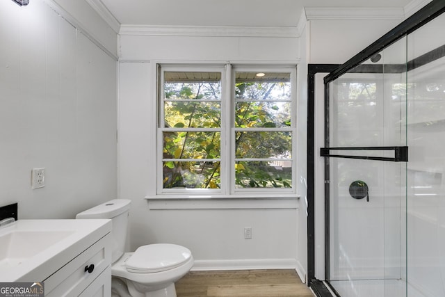 bathroom with vanity, toilet, ornamental molding, and an enclosed shower