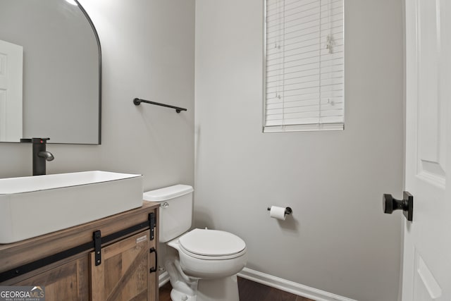 bathroom featuring wood-type flooring, vanity, and toilet