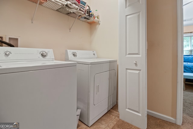 laundry room featuring light colored carpet and separate washer and dryer