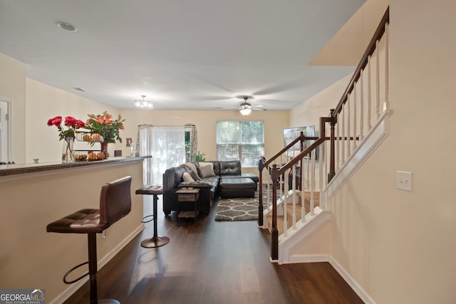 interior space with ceiling fan with notable chandelier and dark wood-type flooring