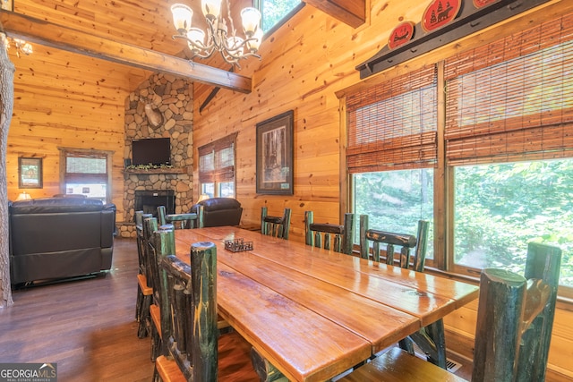 dining room with beam ceiling, dark hardwood / wood-style flooring, plenty of natural light, and a fireplace