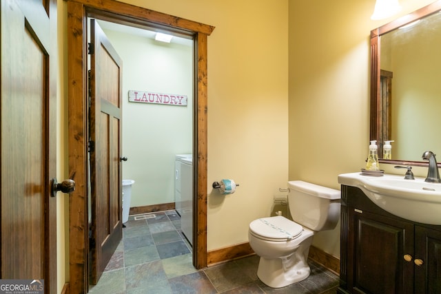 bathroom with vanity, independent washer and dryer, and toilet