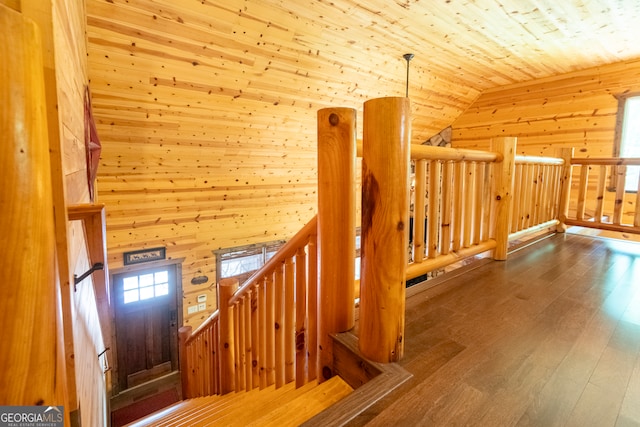 stairway with wood ceiling, wood walls, wood-type flooring, and vaulted ceiling