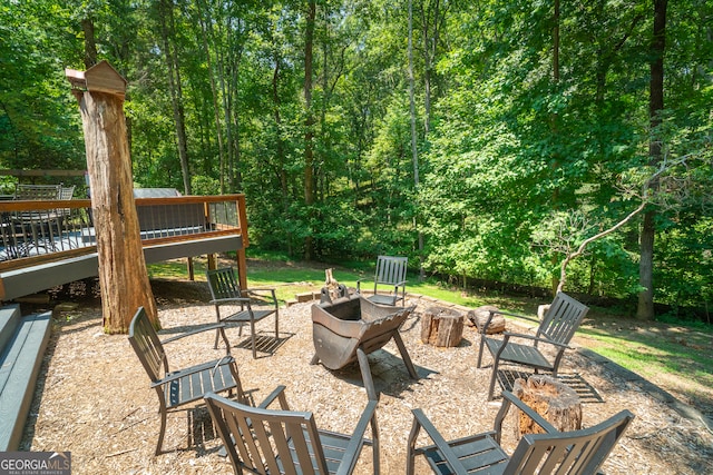 view of patio featuring a wooden deck and an outdoor fire pit