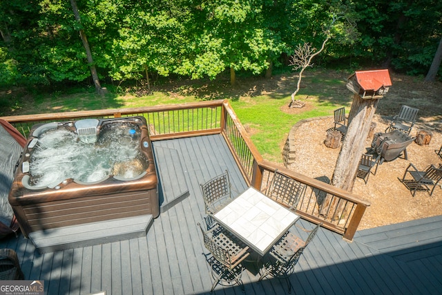 wooden deck with a fire pit and a lawn