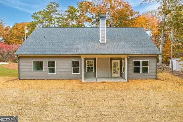 rear view of property with a patio and a yard