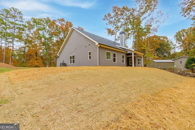 back of property featuring a lawn and central AC unit