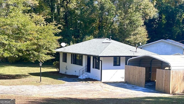 view of front of home with a front yard and a carport