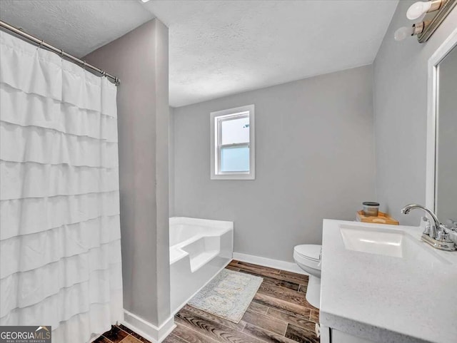 full bathroom featuring hardwood / wood-style floors, separate shower and tub, a textured ceiling, toilet, and vanity