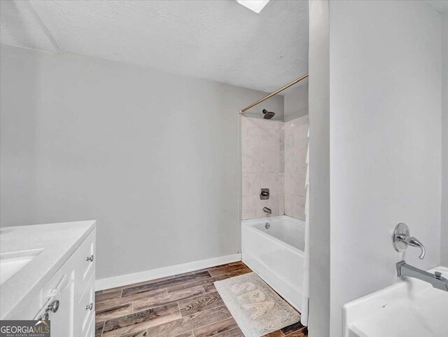 bathroom with vanity, hardwood / wood-style flooring, a textured ceiling, and bathing tub / shower combination