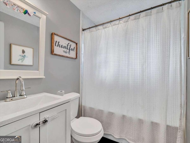 bathroom featuring toilet, a textured ceiling, and vanity