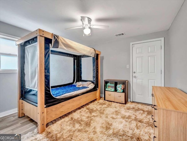 bedroom with light hardwood / wood-style flooring and ceiling fan