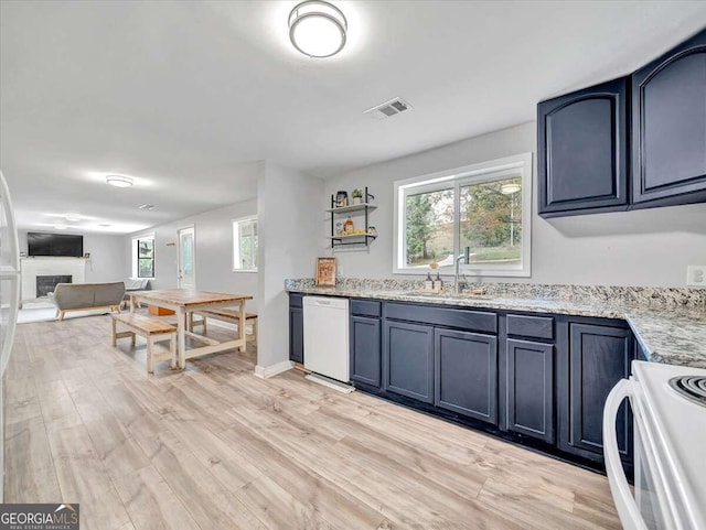 kitchen with blue cabinets, sink, light wood-type flooring, and white appliances