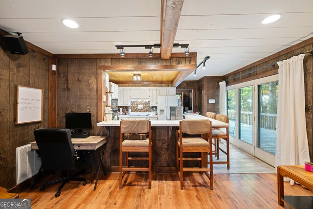 dining space featuring wooden walls and light wood-type flooring