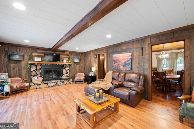 living room with beam ceiling, hardwood / wood-style flooring, wooden walls, and a fireplace