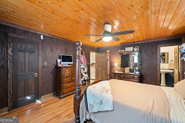 bedroom with connected bathroom, wooden walls, light hardwood / wood-style flooring, wooden ceiling, and ceiling fan