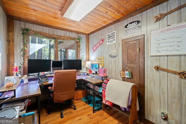 home office with light hardwood / wood-style floors, wood ceiling, and wooden walls