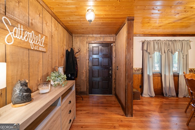 entrance foyer featuring wooden walls, hardwood / wood-style flooring, and wooden ceiling