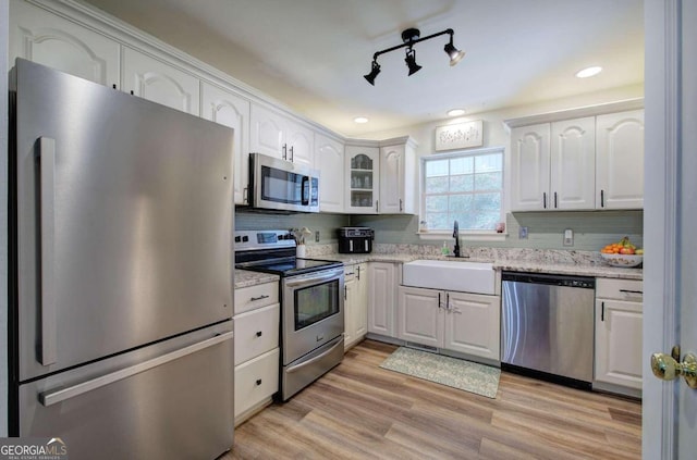 kitchen featuring light hardwood / wood-style flooring, appliances with stainless steel finishes, sink, and white cabinets