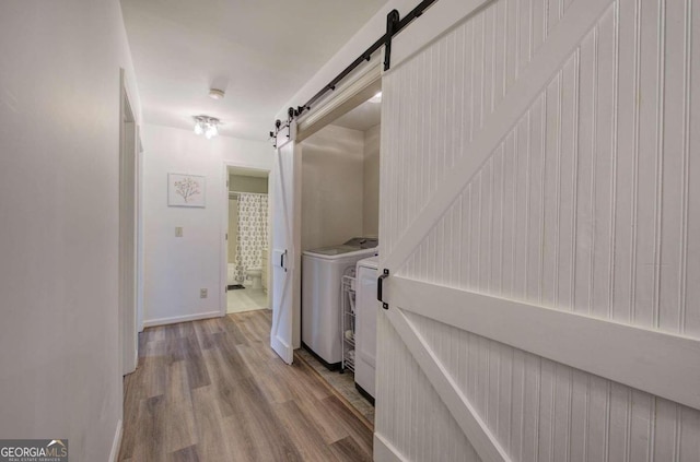 hallway with light hardwood / wood-style flooring and washer and clothes dryer