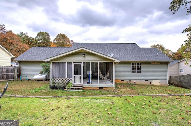 back of property featuring a sunroom and a lawn